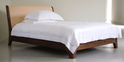 wooden bed with cushioned headboard